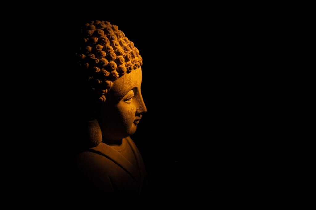 Buddha lit from the side on a dark background